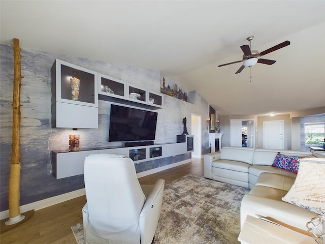 living room with dark hardwood / wood-style flooring, lofted ceiling, and ceiling fan