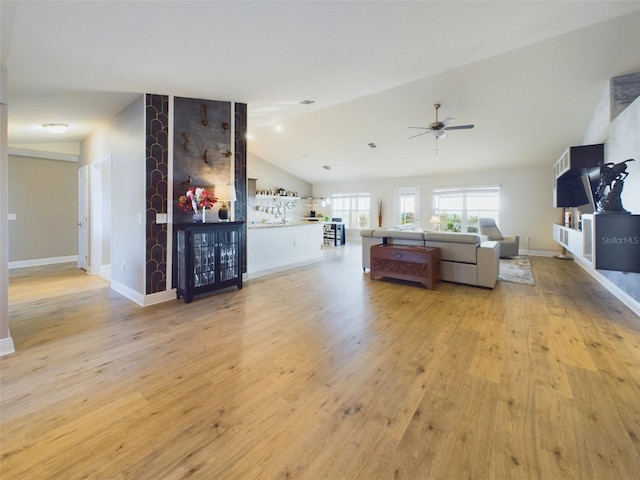 living room with ceiling fan, lofted ceiling, and light hardwood / wood-style floors