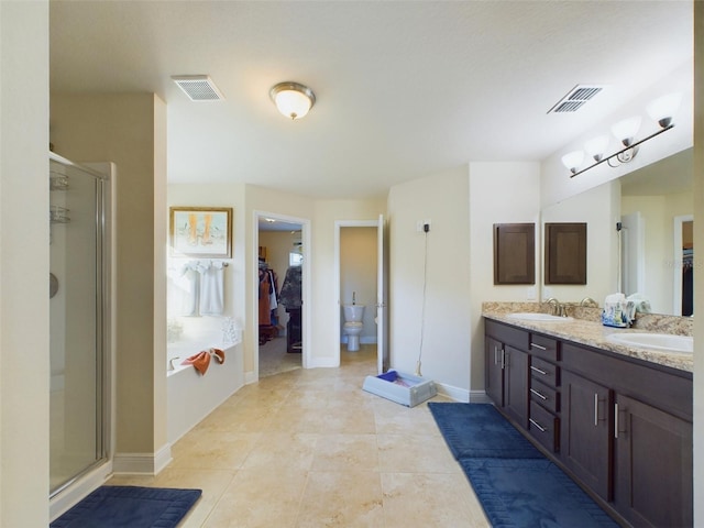 bathroom featuring tile patterned floors, vanity, toilet, and a shower with shower door