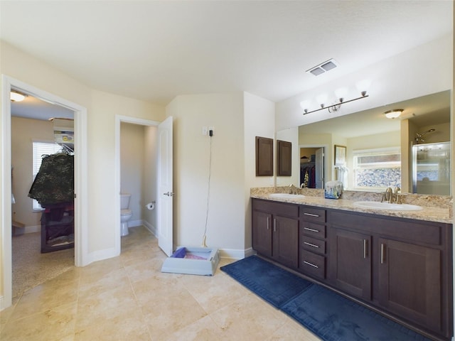 bathroom featuring vanity, toilet, an enclosed shower, and tile patterned flooring