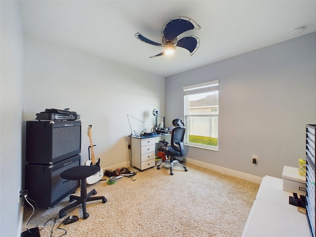 carpeted office space with ceiling fan