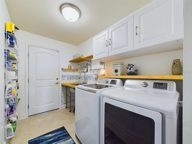 washroom with cabinets, sink, light tile patterned floors, and independent washer and dryer