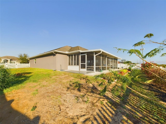 rear view of property featuring a yard and a sunroom