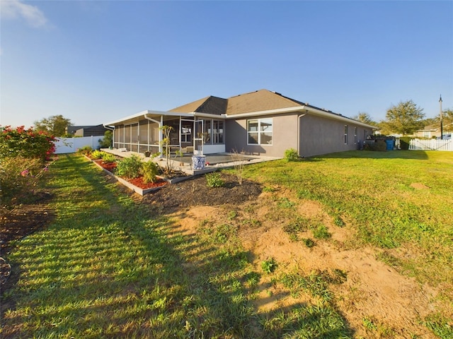 rear view of property featuring a patio, a sunroom, and a yard