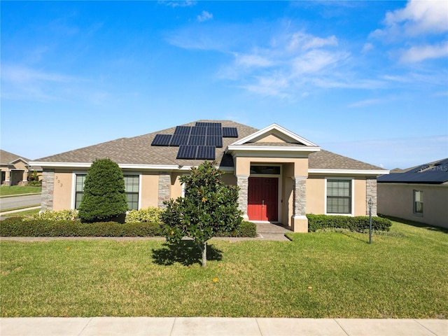 view of front of property with a front lawn and solar panels