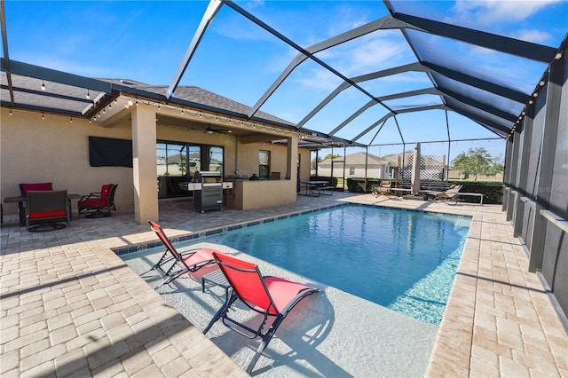 view of pool with ceiling fan, an outdoor bar, a patio, and glass enclosure