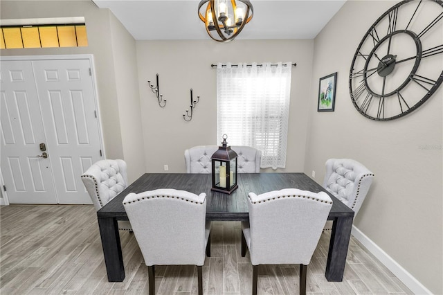 dining space with hardwood / wood-style flooring and an inviting chandelier