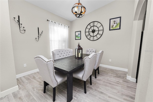 dining space with a chandelier and light hardwood / wood-style flooring