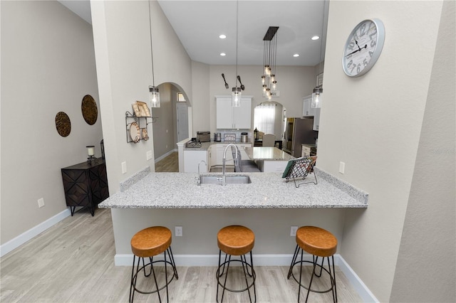 kitchen with kitchen peninsula, pendant lighting, and a breakfast bar