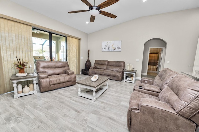 living room featuring ceiling fan, light hardwood / wood-style floors, and lofted ceiling