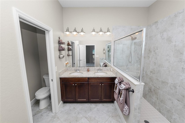 bathroom featuring tiled shower, vanity, and toilet