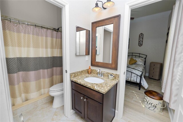 bathroom featuring curtained shower, vanity, and toilet