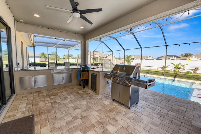 view of patio featuring glass enclosure, ceiling fan, grilling area, a fenced in pool, and area for grilling