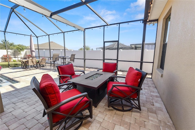 view of patio / terrace featuring glass enclosure and a fire pit