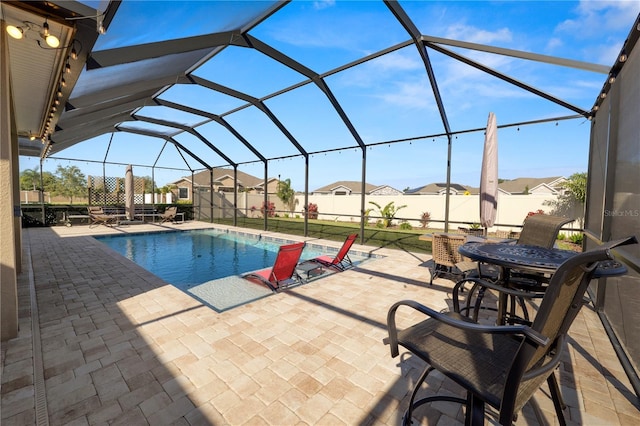 view of swimming pool with glass enclosure and a patio