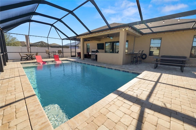 view of swimming pool featuring a lanai, a patio area, ceiling fan, and exterior bar