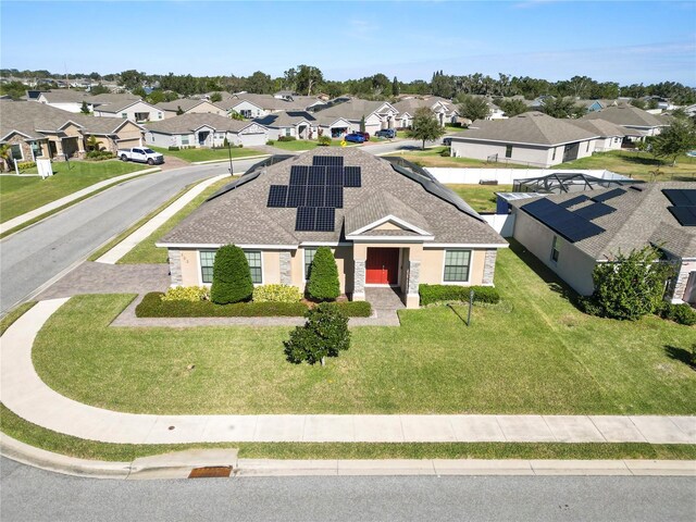 view of front of house with solar panels and a front yard