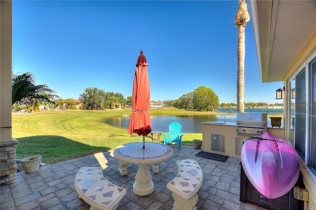 view of patio / terrace featuring a water view, area for grilling, and sink