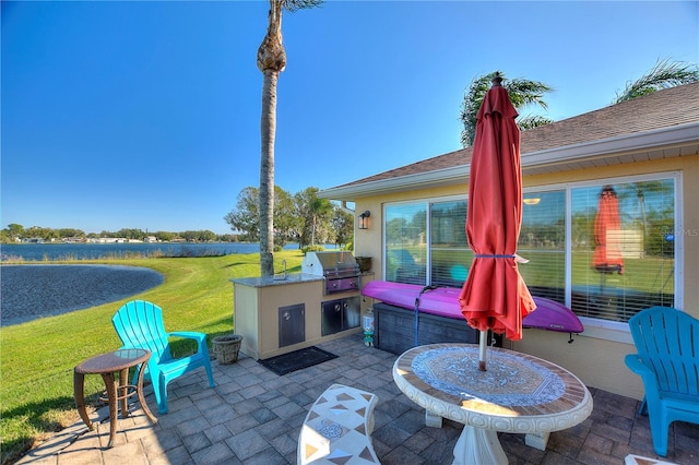 view of patio with area for grilling and a grill