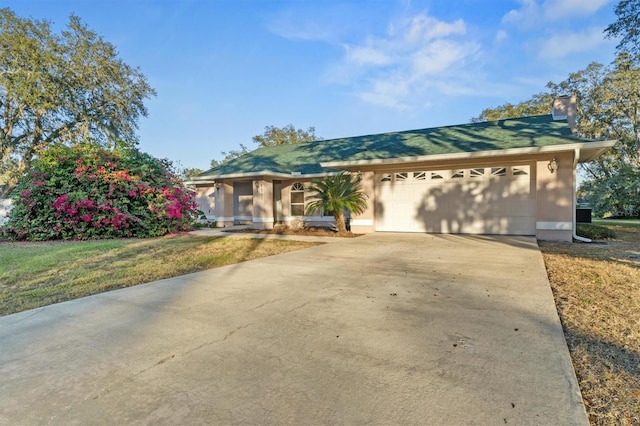 single story home featuring a front lawn and a garage