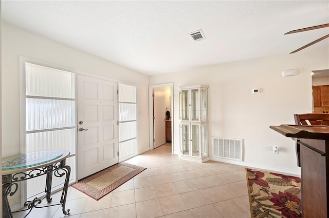 tiled foyer entrance with ceiling fan