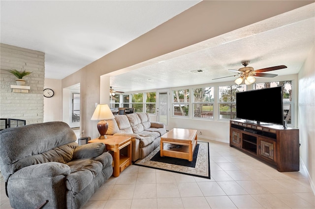 living room with a healthy amount of sunlight, light tile patterned flooring, a textured ceiling, and a brick fireplace