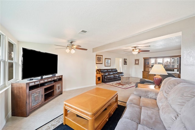 tiled living room featuring ceiling fan and a textured ceiling