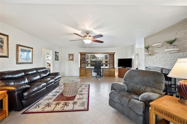 tiled living room featuring ceiling fan and a fireplace