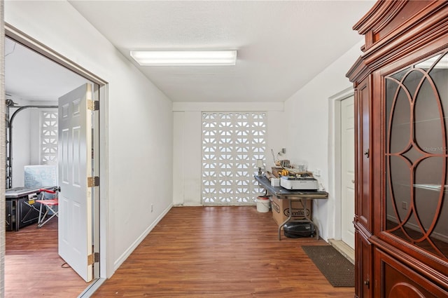 corridor with wood-type flooring and a textured ceiling