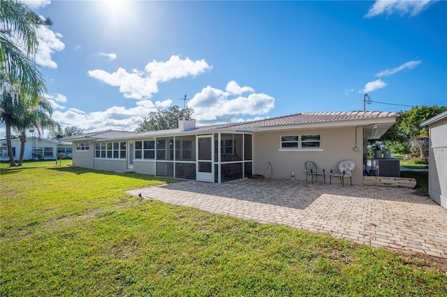 back of house featuring a patio, a sunroom, and a lawn