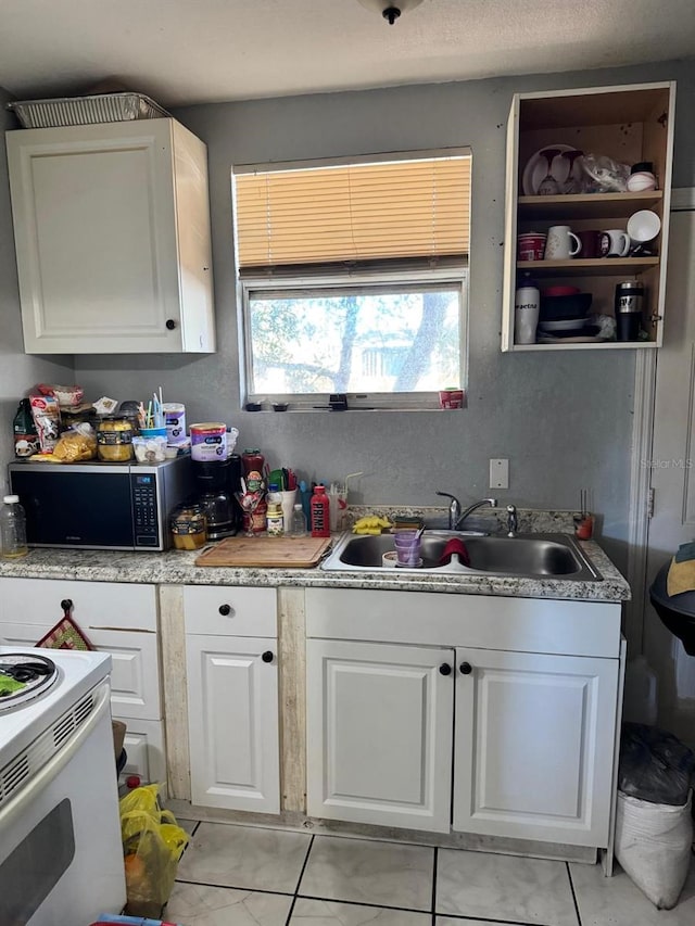 kitchen featuring white cabinets, white range with electric cooktop, and sink