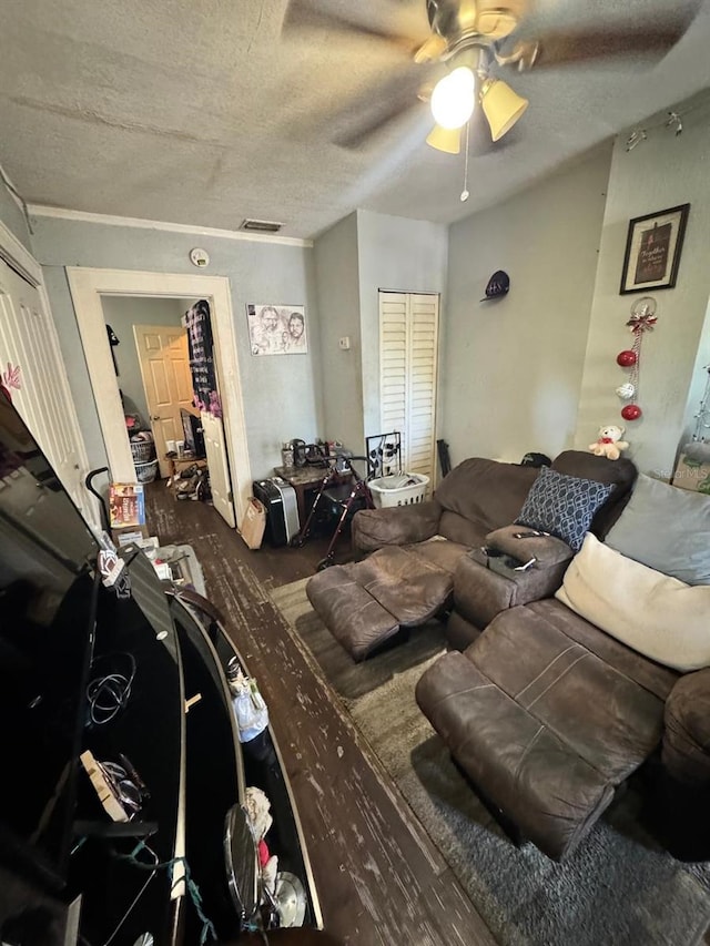 living room featuring ceiling fan, dark hardwood / wood-style flooring, and a textured ceiling