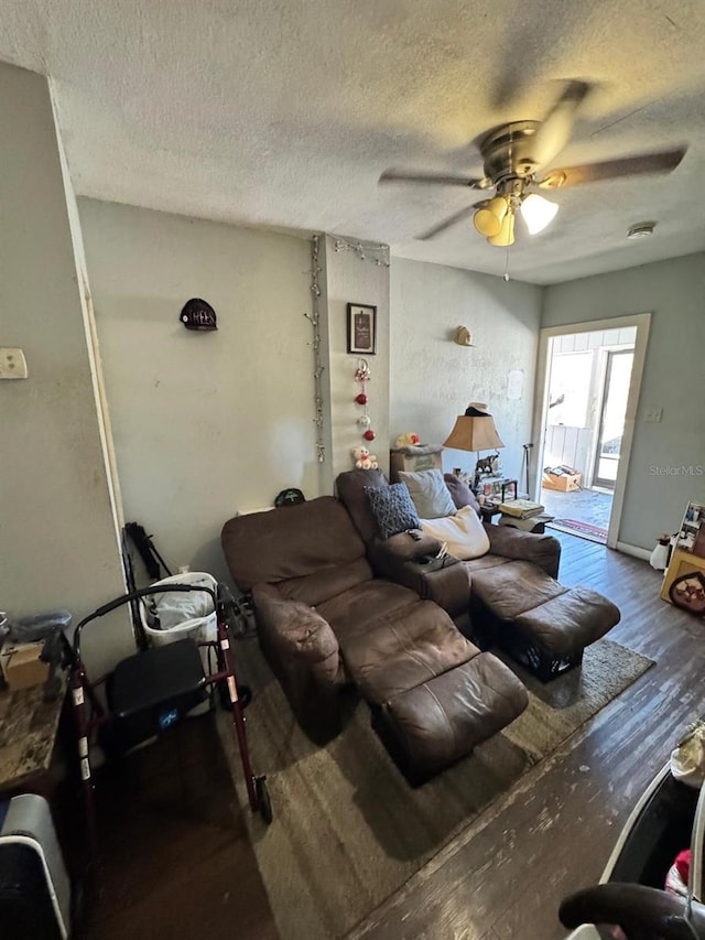 living room featuring ceiling fan, wood-type flooring, and a textured ceiling