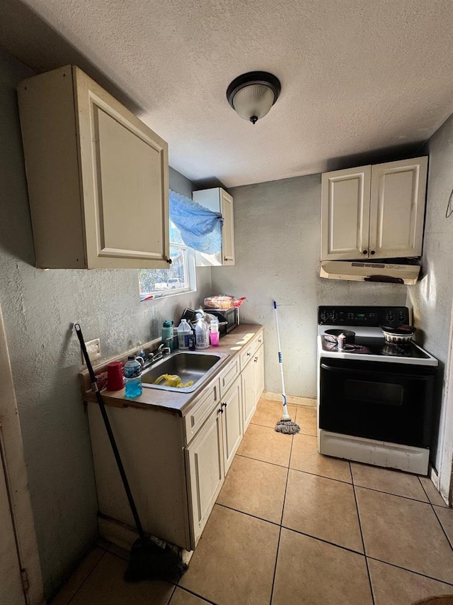 kitchen with sink, light tile patterned flooring, white electric range oven, and a textured ceiling