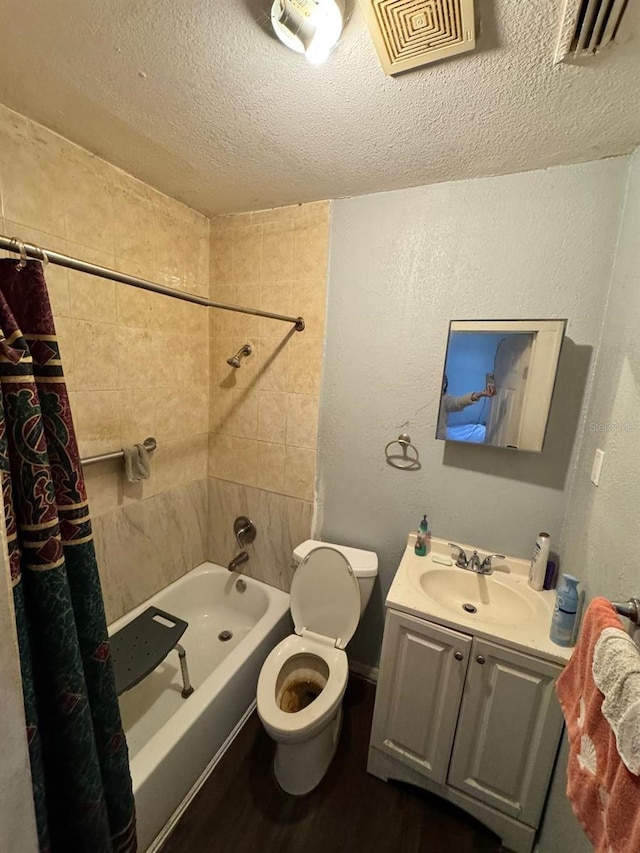 full bathroom featuring vanity, shower / tub combo, a textured ceiling, and toilet