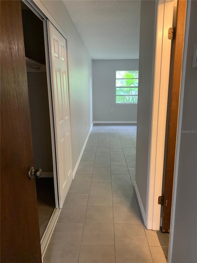 hall with light tile patterned floors