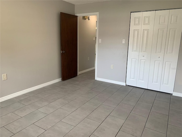 unfurnished bedroom with a closet and light tile patterned flooring