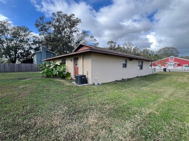 view of side of property with cooling unit and a yard