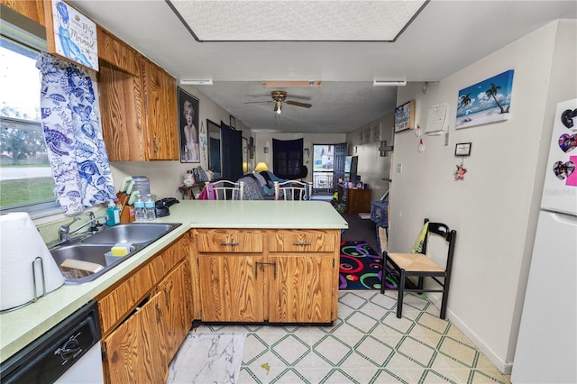 kitchen with ceiling fan, white appliances, kitchen peninsula, and sink