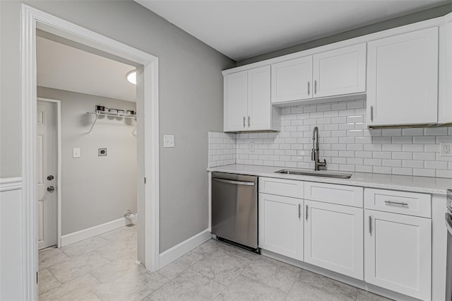 kitchen with light stone countertops, sink, stainless steel dishwasher, backsplash, and white cabinets