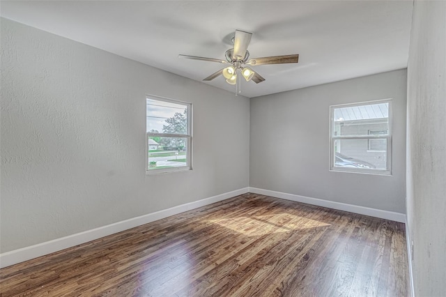 spare room featuring dark hardwood / wood-style flooring and ceiling fan