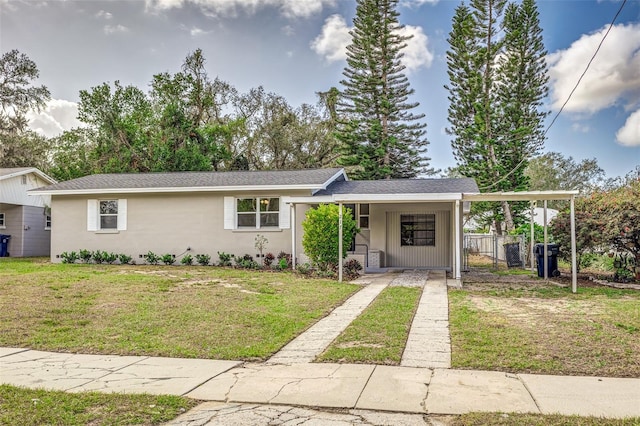 view of front of home with a carport and a front lawn