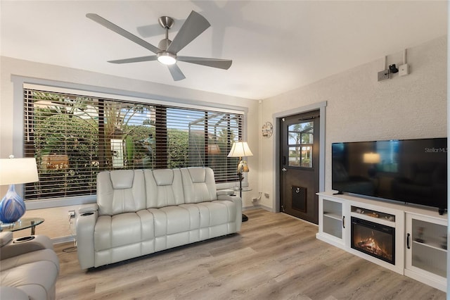 living room with light hardwood / wood-style flooring and ceiling fan
