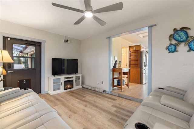 living room featuring ceiling fan and light hardwood / wood-style floors