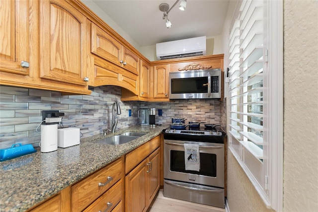 kitchen featuring sink, decorative backsplash, dark stone countertops, stainless steel appliances, and a wall unit AC