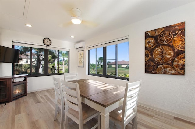 dining space with an AC wall unit and light wood-type flooring