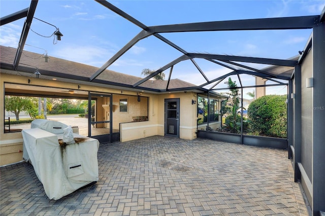 view of patio with grilling area and a lanai