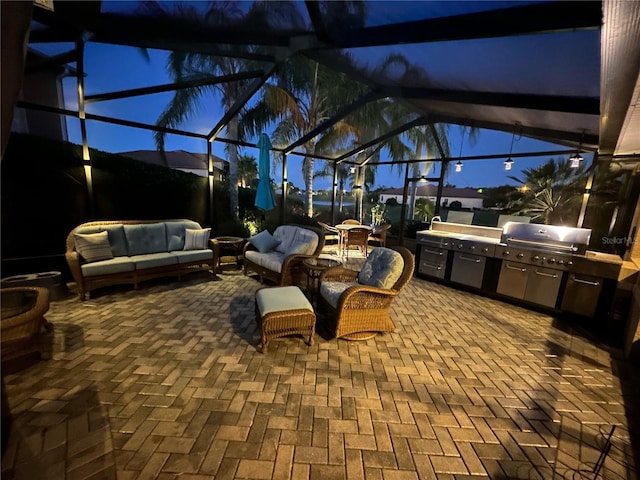 view of patio featuring glass enclosure, outdoor lounge area, exterior kitchen, and grilling area