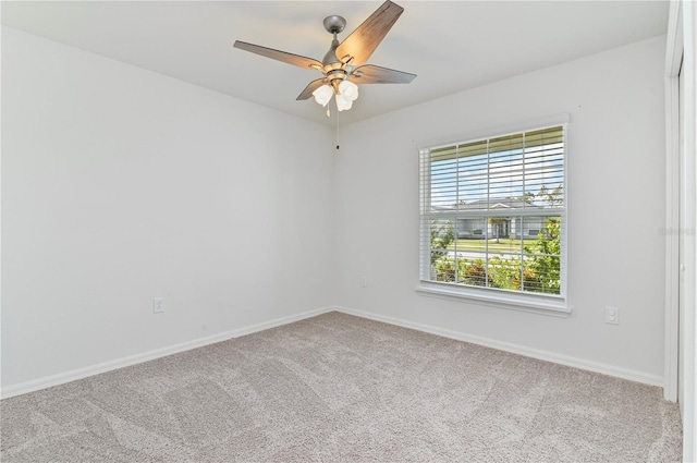 carpeted spare room featuring ceiling fan