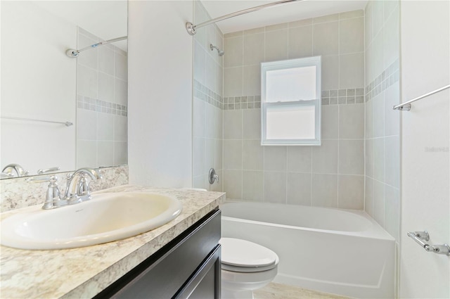 full bathroom with vanity, tiled shower / bath, and toilet